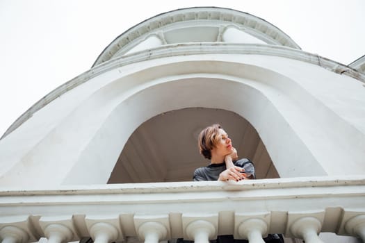 woman in black clothes posing near a white building