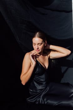 Portret of beautiful fashionable woman in black silk dress