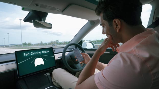 Self driving car or autonomous vehicle travel on speed highway with driverless system and autopilot mode allowing man driver relax and focus on smartphone without compromising safety. Perpetual