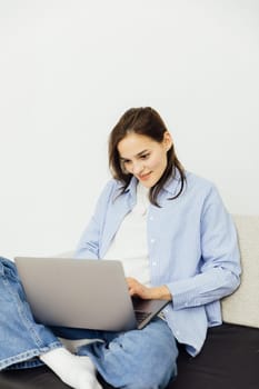 Woman working on laptop sitting on sofa