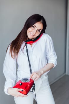 woman talking on old wired phone