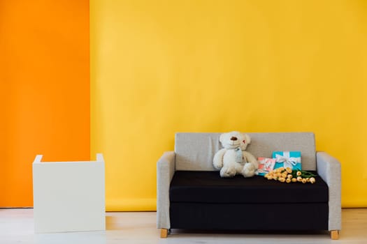 Black and grey sofa in the interior of a multicolored room