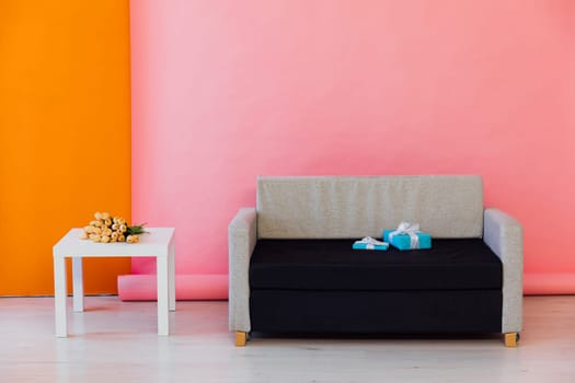 Black and grey sofa in the interior of a multicolored room
