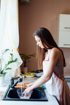 girl housewife washes dirty dishes in the kitchen 1