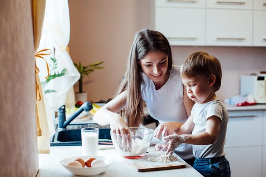 mother and son prepare pie sprinkled with flour