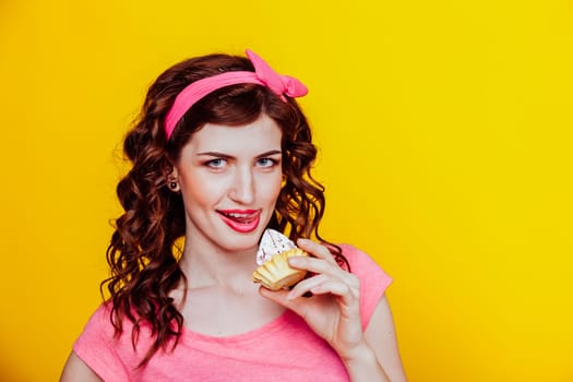 girl in pink dress pinup-style eats cake with cream 1