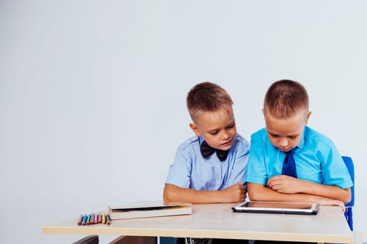 the two boys are looking at Internet Tablet school 1