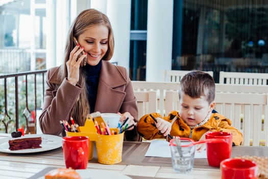 Restaurant mom with son talking on the phone 1