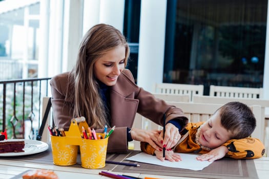 mother and son draw drawing hands colored pencils