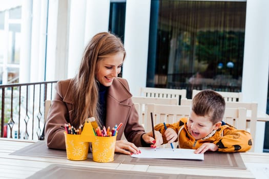 mom and young boy draw colored pencils 1