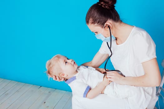 the doctor listens to the little boy stethoscope in hospital