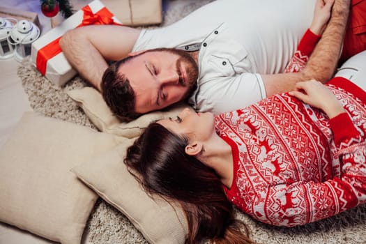 the guy with the girl lying on the floor at the new year Christmas tree 1