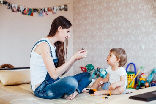 mother and little boy play with toys in the nursery 1