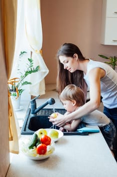 mom teaches boy wash products in the sink