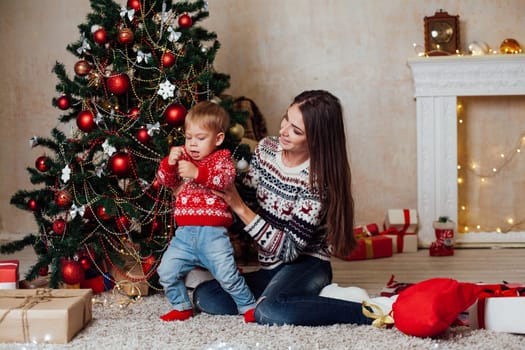 mom with son decorate the Christmas tree on new year's Day Gifts Christmas