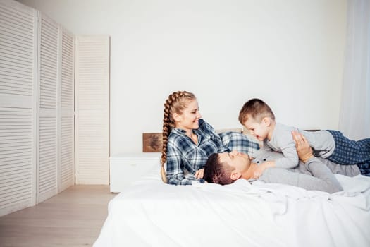 mom dad and son in the morning woke up lying on the bed at home