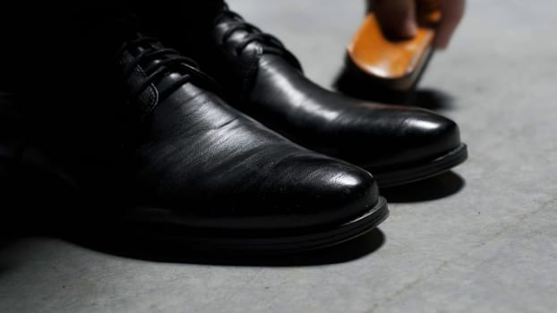Waxing leather black classic shoes. Stock footage. Close up of cleaning and polishing boots