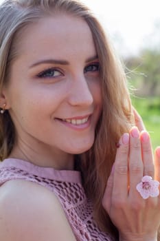 Portrait of a beautiful blonde woman in a pink dress and a ladybug