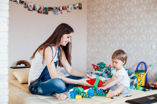 mother and little boy play with toys in the nursery 1