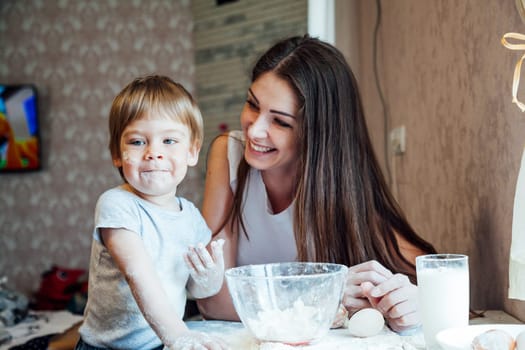 mother and young son prepare a cake in the kitchen 1