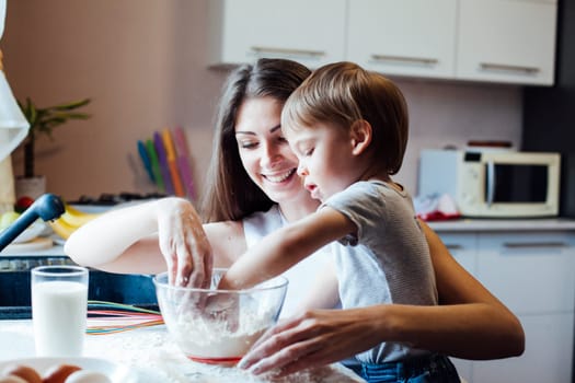 mother and son prepare pie sprinkled with flour
