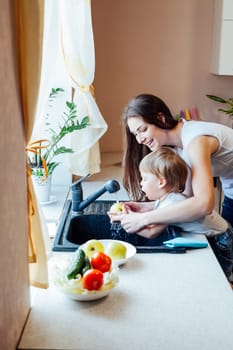 mom teaches boy wash products in the sink