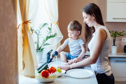 mom cleans the vegetables in the kitchen boy it interferes