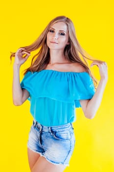 beautiful blonde girl on a yellow background in blue dress 1