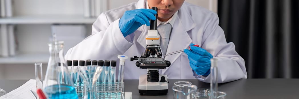 Scientist conduct chemical experiment using microscope in medical laboratory to develop new vaccine drug or antibiotic. Biotechnology lab and medicine research concept. Neoteric