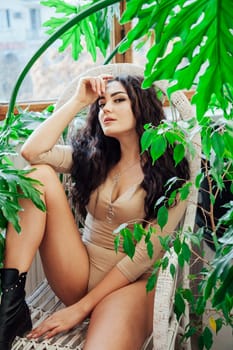 portrait of a beautiful brunette woman in a chair by a green tree