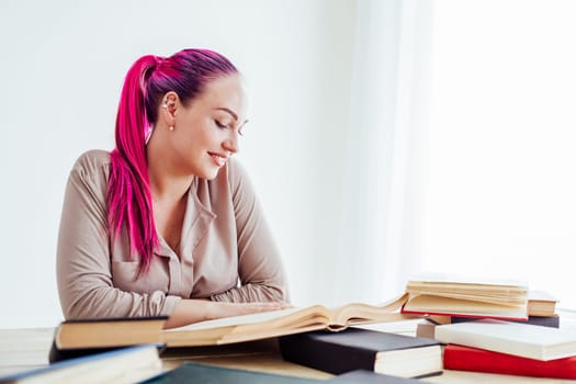 business woman with pink hair sits in the Office reads books education 1