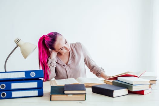 business woman with pink hair sits in the Office reads books education 1