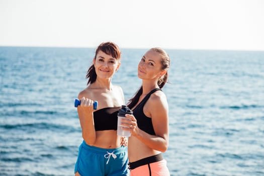 two girls play sports on the beach by the sea