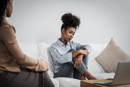 Sad PTSD woman patient in crucial therapy for mental health with psychologist, depression or grief after life failure. Frustrated trauma young woman talking to a psychologist about emotion in clinic