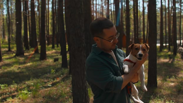 Man holds dog in arms and rejoices. Stock footage. Man holds dog in arms and strokes it. Man holds dog in arms on sunny summer day.