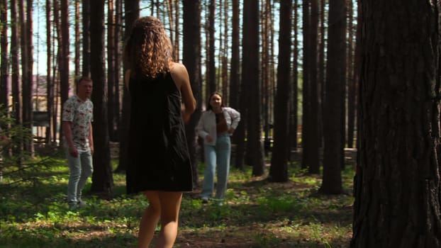 People play volleyball in forest. Stock footage. Tourists at recreation center play volleyball in forest. Vacationing people play ball in forest on sunny summer day.
