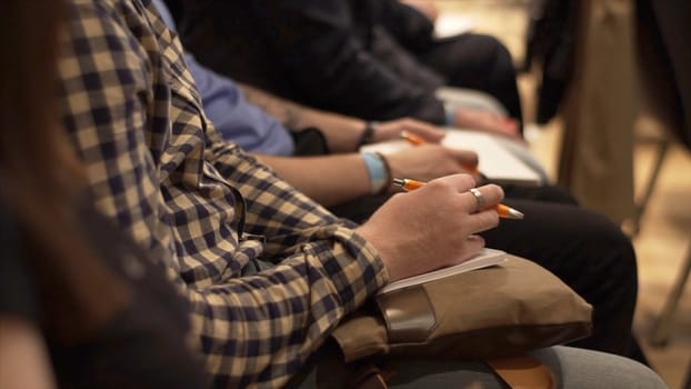 Close-up of Hands holding pens at the conference. Stock. Training, Business, Presentation.