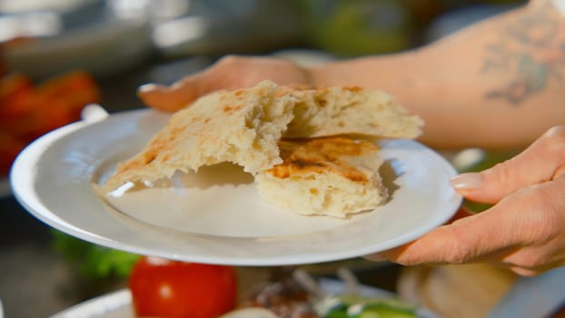 Close-up of people cutting and preparing table in nature. Stock footage. People relax in nature with appetizing table with vegetables. Bright table with vegetables and barbecue in nature.