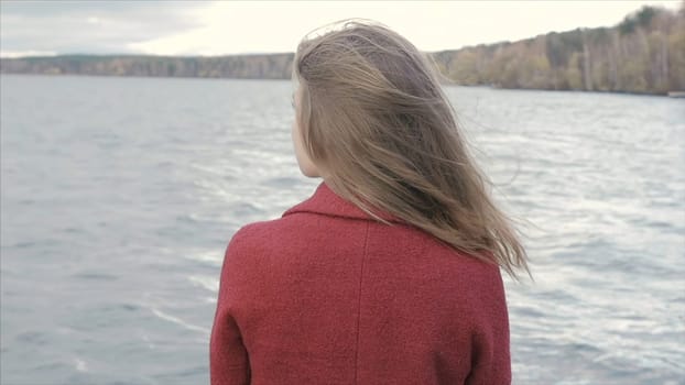 Rear View Of Young Woman Enjoying Lake View. Rear view of alone young adult hipster girl standing on the beach, looking to sea, travel lifestyle p