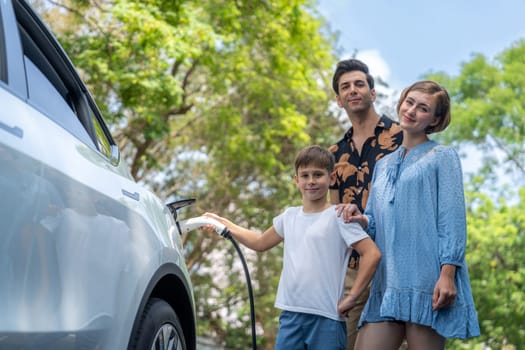 Family road trip vacation with electric vehicle, lovely family recharge EV car with green and clean energy. Natural and eco friendly car travel for sustainable environment. Perpetual