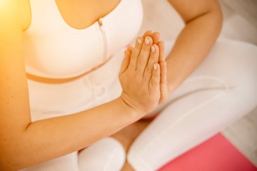 Girl does yoga. Young woman practices asanas on a beige one-ton background