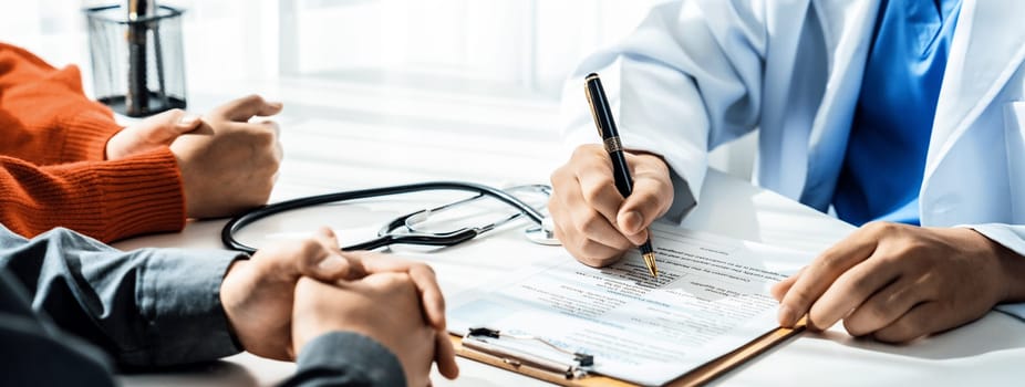 Couple attend fertility consultation with gynecologist at hospital as part family planning care for pregnancy. Loving husband and wife support each other through the doctor appointment. Panorama Rigid