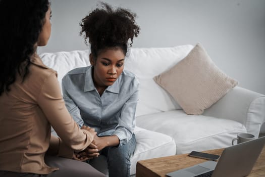 Sad PTSD woman patient in crucial therapy for mental health with psychologist, depression or grief after life failure. Frustrated trauma young woman talking to a psychologist about emotion in clinic