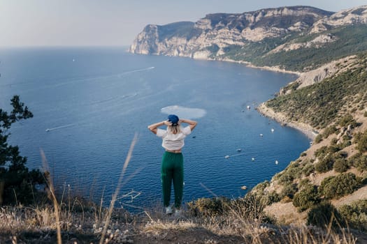 Happy woman standing with her back in nature in summer with open hands posing with mountains. Woman in the mountains, eco friendly, summer landscape active rest.