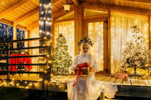 A woman in a white dress holding a gift box.