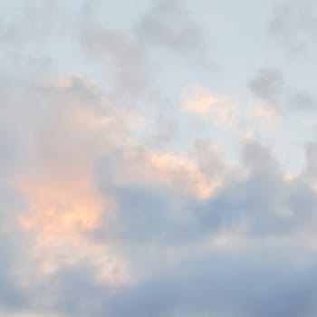 Background of blue sky with pale pink clouds at sunset