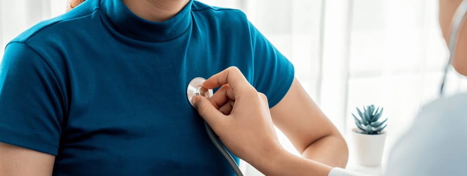 Patient attend doctor's appointment at clinic or hospital office. Doctor examining and diagnosis symptoms while checking the patient's pulse with stethoscope. Panorama Rigid