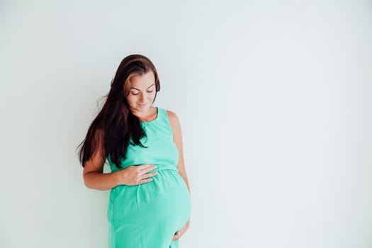 a pregnant woman is standing at the wall next to the window 1