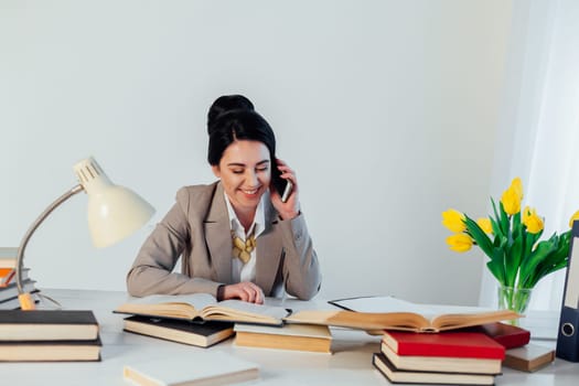 a woman in a business suit talking on the Smartphone at the table