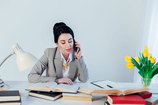 brunette woman in a business suit talking on the phone in the Office 1